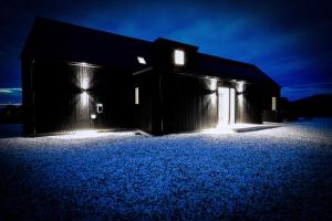 a barn with lights on the side of it at night at Black Barn Skye - Contemporary 3 bed / 4 bath home in Broadford
