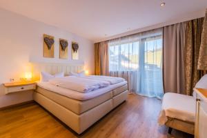 ein Schlafzimmer mit einem Bett und einem großen Fenster in der Unterkunft Allgäu Vital Oberstaufen inkl Oberstaufen Plus Card in Oberstaufen + 91 Fotos