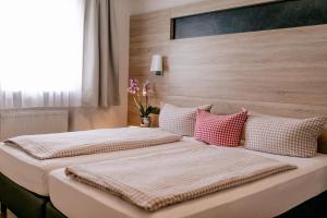 dwa łóżka siedzące obok siebie w sypialni w obiekcie Hotel Vogtareuther-Hof w mieście Vogtareuth