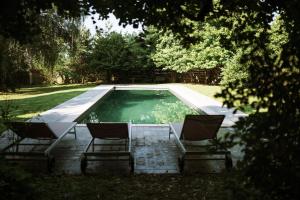 two chairs and a swimming pool in a yard at Maison Durieux in Limoges