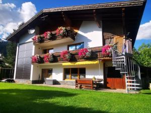 巴赫的住宿－Haus Maria Larcher，阳台和长凳上鲜花的房子