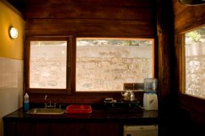 a kitchen with two windows and a counter top at Finca La Colorada in San Salvador de Jujuy