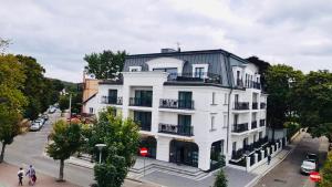 a white building with a black roof on a city street at Luxury Apartments in Residence Maritime in Międzyzdroje