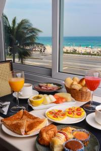 uma mesa com pratos de comida e vista para a praia em Sol Ipanema Hotel no Rio de Janeiro