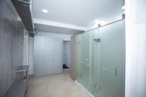 baño con ducha a ras de suelo y puerta de cristal en SULO Apartments en Atyraū