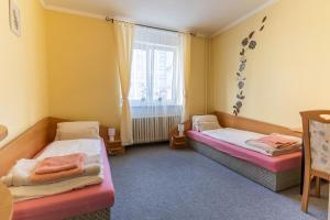 a room with two beds and a window at Penzion Na Starém náměstí in Sokolov