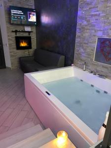 una grande vasca da bagno in un soggiorno con camino di Sweetlove Spa a Terracina