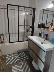a bathroom with a sink and a shower and a tub at Monts repos! in Monts