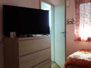 - une chambre avec une télévision à écran plat sur une commode dans l'établissement Gästezimmer Herzogenrath, à Herzogenrath