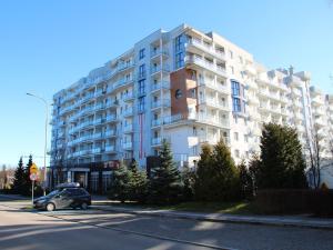 科沃布熱格的住宿－Apartament prywatny w kompleksie hotelowym przy ul Kościuszki 16，停在大楼前的汽车