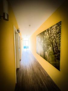 a hallway with a painting on a yellow wall at Hotel Altbacher Hof in Altbach