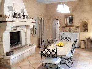 eine Küche mit einem Tisch mit Stühlen und einem Kamin in der Unterkunft Villa raffinée à Orange avec piscine privée in Orange