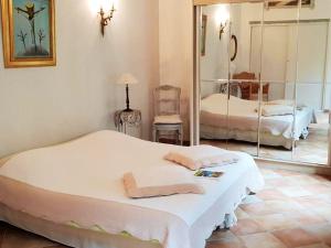 ein Schlafzimmer mit einem großen weißen Bett und einem Spiegel in der Unterkunft Villa raffinée à Orange avec piscine privée in Orange