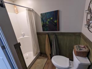La salle de bains est pourvue d'une douche et de toilettes blanches. dans l'établissement The Estate Studio in Downtown Milford, à Milford