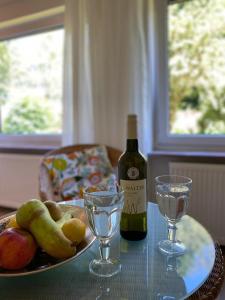 a bottle of wine and two glasses on a table at Ferienwohnung miraBelle in Erbach im Odenwald