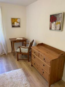 a bedroom with a wooden dresser and a table with a chair at Ferienwohnung miraBelle in Erbach im Odenwald