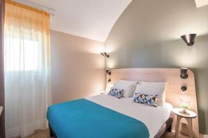 Un dormitorio con una cama azul y blanca y una ventana en Appart'City Confort Montpellier Saint Roch, en Montpellier
