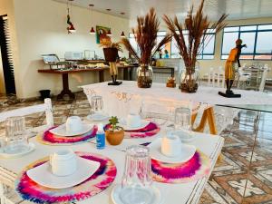 a table with white plates and hats on it at Cambará Suítes in Bonito