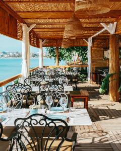 a restaurant with tables and chairs on a deck at Side Kleopatra Hotel in Side