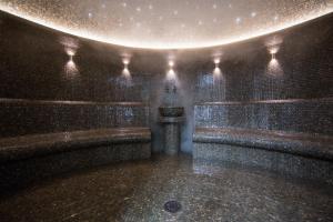 a dark room with a fountain with lights on it at Caucasus Hotel in Yerevan