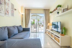 un soggiorno con un divano blu e una TV di El Dorado Garden View PH04 ad Arona Altre 26 foto