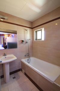 y baño con bañera y lavamanos. en 墾丁貝殼灣旅店, en Kenting