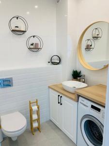 łazienka z umywalką i pralką w obiekcie Apartament Premium w mieście Słupsk