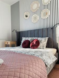 ein Schlafzimmer mit einem Bett mit zwei roten Kissen darauf in der Unterkunft Apartament Premium in Słupsk