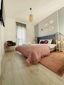 ein Schlafzimmer mit einem Bett mit einer rosa Decke in der Unterkunft Apartament Premium in Słupsk