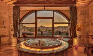 a room with a bath tub in a room with a window at Şah Saray Cave Suites Halal Hotel in Göreme