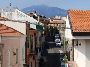 una strada cittadina con edifici e un'auto sulla strada di La Casa de Maia a Belpasso