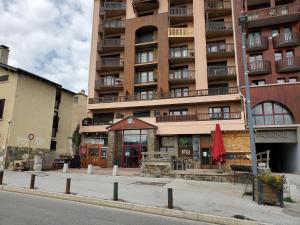 a large apartment building with a restaurant in front of it at Agréable appartement-Résidence Le Panoramic in Les Angles