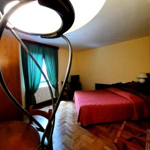 a bedroom with a red bed and a large light at Hotel Bellavista in Abetone