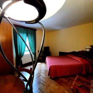 una camera da letto con un letto rosso e una grande luce di Hotel Bellavista ad Abetone