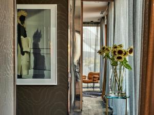 um corredor com um vaso de flores na parede em H15 Boutique Hotel, Warsaw, a Member of Design Hotels em Varósvia