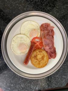 a plate of food with eggs sausage and potatoes at Casa Calida Guest House in Upington