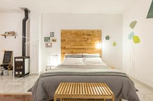 1 dormitorio con 1 cama grande y cabecero de madera en Alloggio OpenSpace da Irene, en San Giovanni Lupatoto