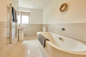 a white bathroom with a tub and a sink at Wildhaven- Idylic rural farmhouse with log burner and countryside views in Gwynfe