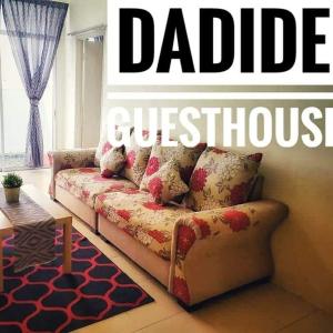 um sofá numa sala de estar com as palavras ddbucucossession writtenrophe em Dadide guesthouse em Kampong Alor Gajah