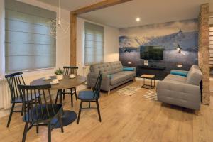 卡爾帕奇的住宿－Apartamenty Sun Seasons 24 - Willa Karpacz，客厅配有桌子、沙发和电视。
