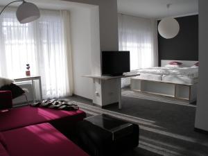 バート・シュテーベンにあるHaus Katharina Hotel garniのベッドルーム(ベッド1台、テレビ、ソファ付)