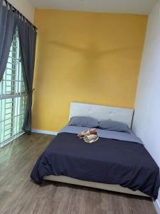 a bedroom with a bed with a yellow wall at Baojuwu 1 Bedroom Akademik Suites Austin Heights in Johor Bahru