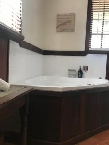 een groot bad in een badkamer met een wastafel bij Oak Tree Barn Bridgetown in Bridgetown