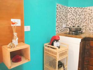 a kitchen with a blue wall and a counter top at Chalé de Charme Mandomai in Ilhabela