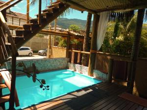 a swimming pool on the deck of a house at Chalé de Charme Mandomai in Ilhabela
