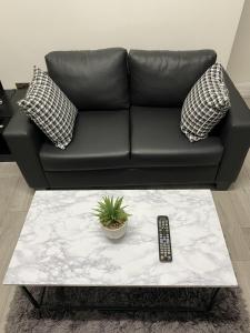 a black leather couch with a remote control on a table at BVapartments-queengate 3 in Huddersfield