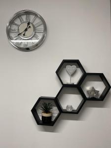 a clock and a potted plant on a wall at BVapartments-queengate 3 in Huddersfield