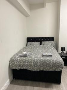 a bedroom with a bed with a gray and white comforter at BVapartments-queengate 3 in Huddersfield