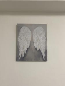 two white wings on a picture on a wall at BVapartments-queengate 3 in Huddersfield