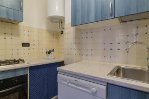 cocina con azulejos azules y blancos y fregadero en SUITE CRISTINA en Verona